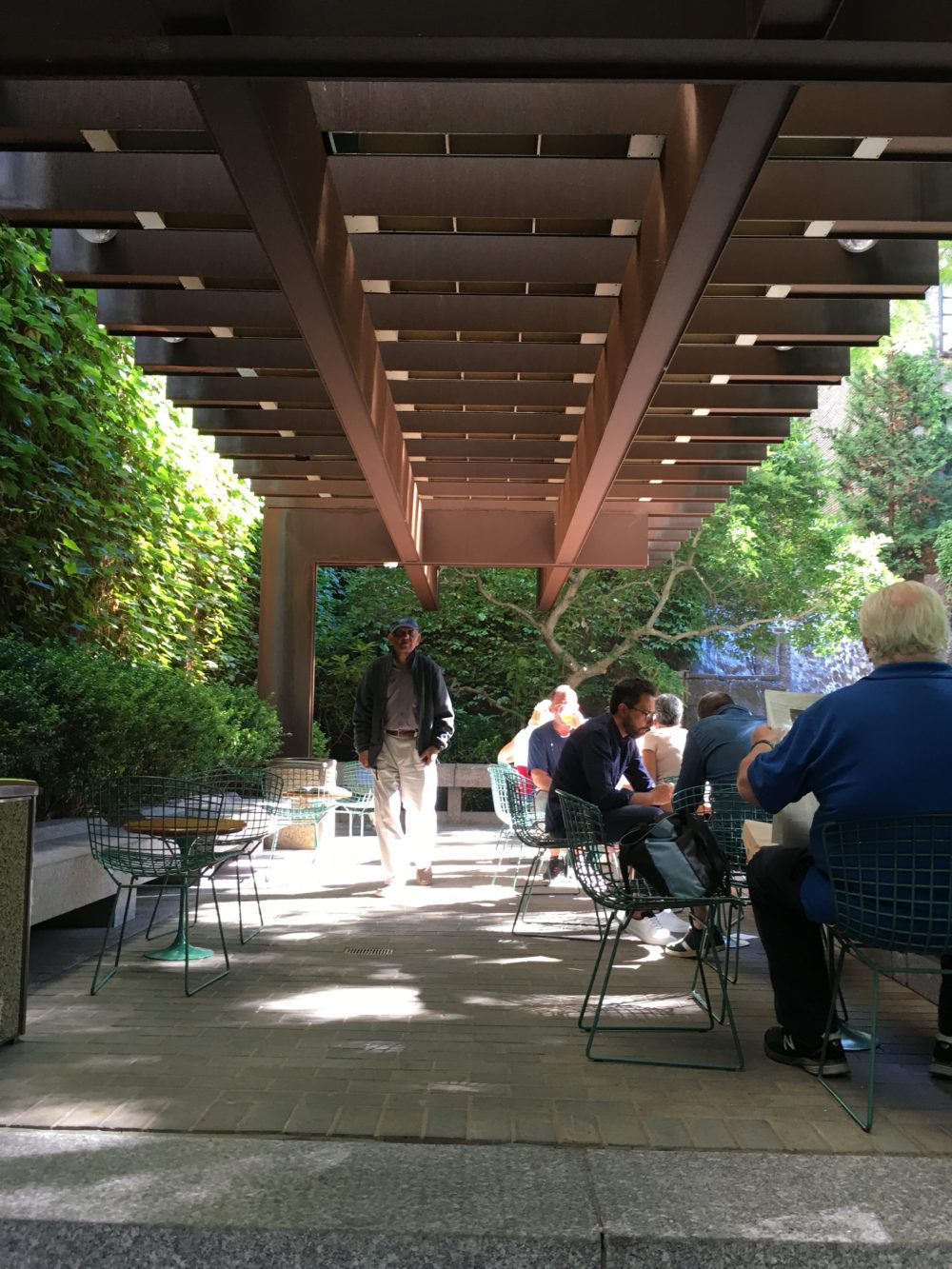 A group of people sitting under an awning.