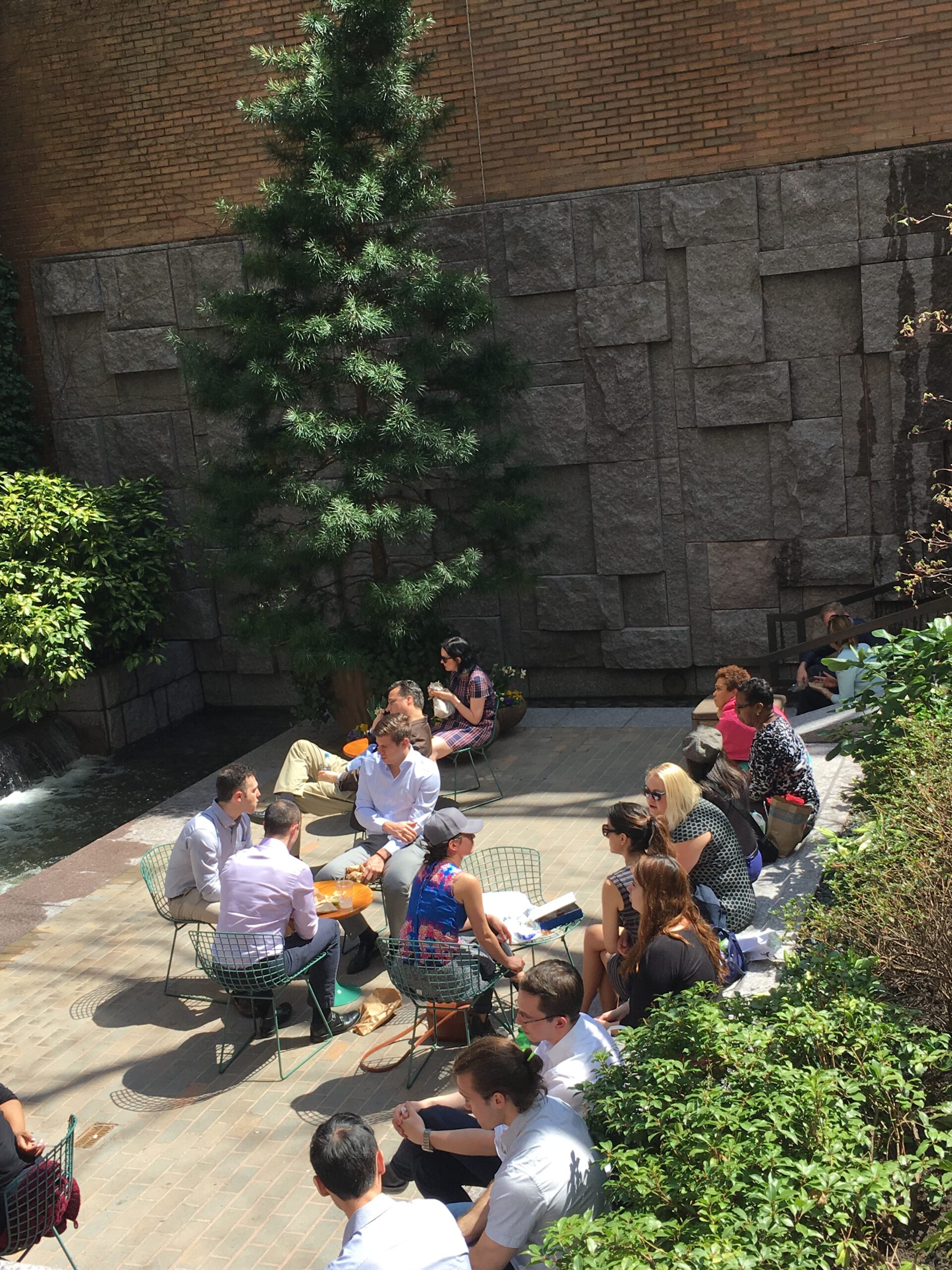 A group of people sitting on the ground outside